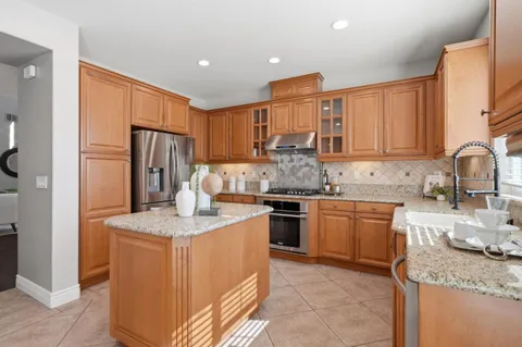 a kitchen with stainless steel appliances granite countertop a sink stove and refrigerator