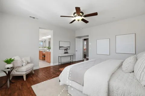 a spacious bedroom with a bed and a wooden floor