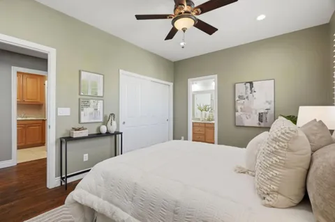 a bedroom with a large bed and wooden floor