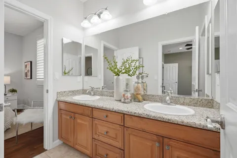 a bathroom with double vanity sinks a vanity a lamp and a mirror