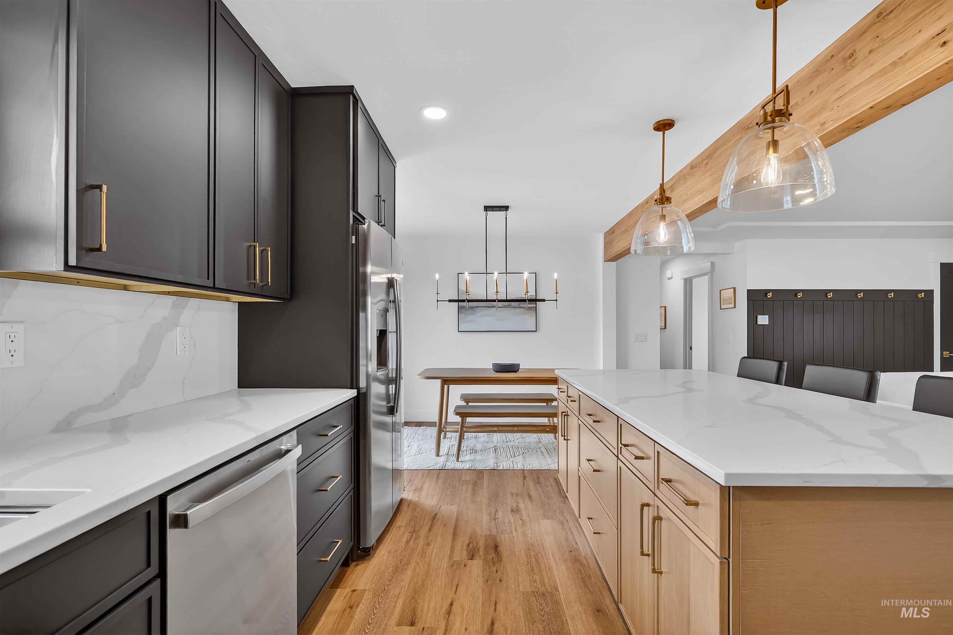 3513 8th Street Lewiston, ID 83501 - Photo 16 of 41 Dual tone kitchen featuring stainless steel appliances, light stone counters, dual tone cabinets, light wood finished floors, and pendant lighting