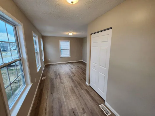 a view of a hallway with wooden floor and staircase