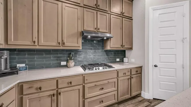a kitchen with stainless steel appliances granite countertop a sink a stove and cabinets