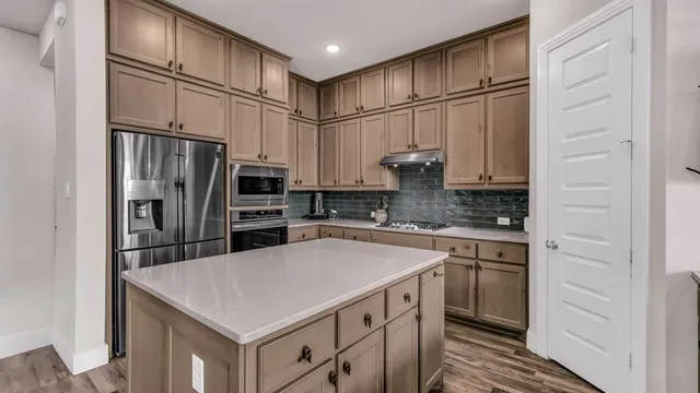 a kitchen with stainless steel appliances a refrigerator sink and cabinets