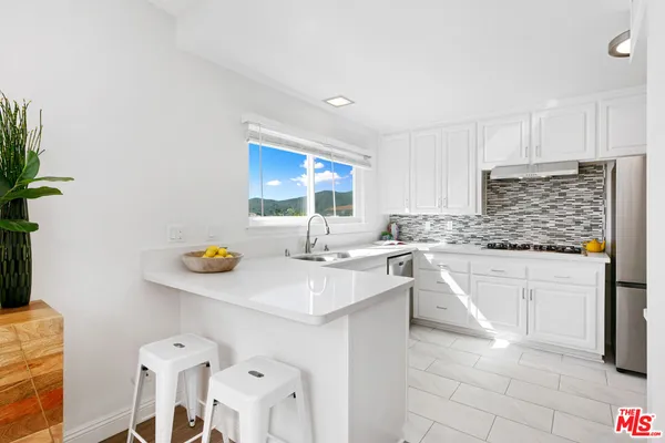 a kitchen with a sink cabinets and wooden floor