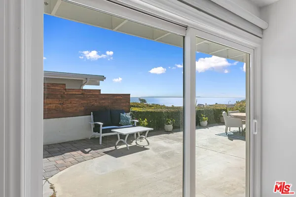 a outdoor space with a large window and couches chair