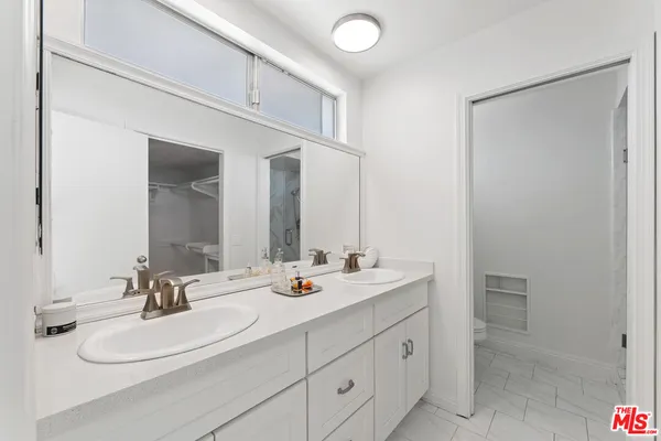 a bathroom with a double vanity sink and mirror