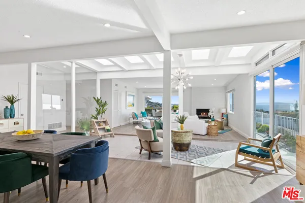 a living room with furniture wooden floor and a large window