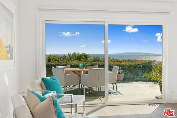 a view of a dining room with furniture and floor to ceiling window