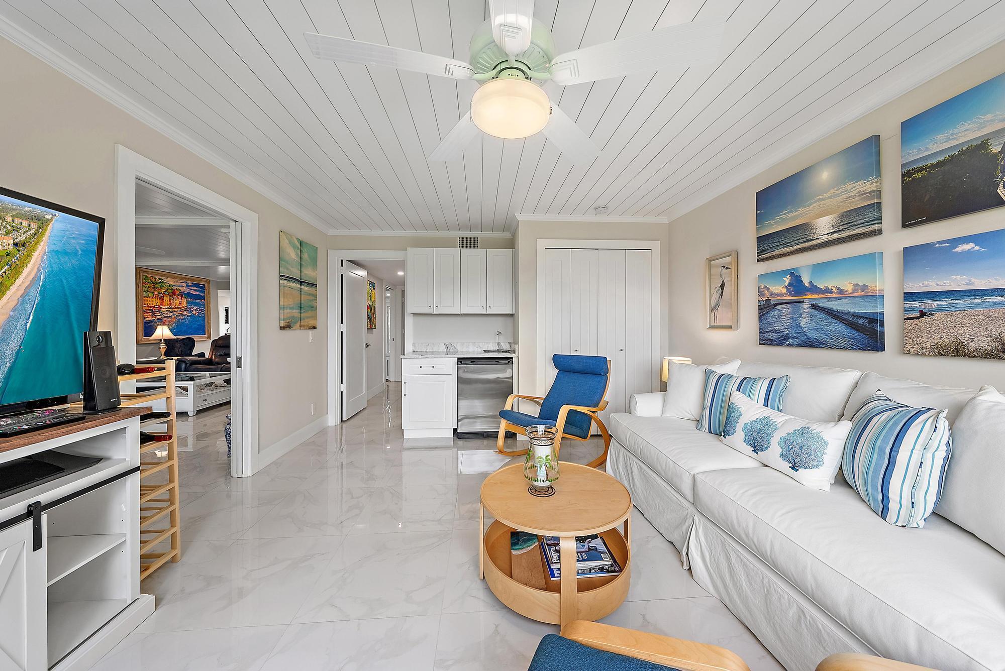 3693 Quail Ridge Drive, Unit BOBWHITE B Boynton Beach, FL 33436 - Photo 15 of 39 a living room with furniture a chandelier and kitchen view