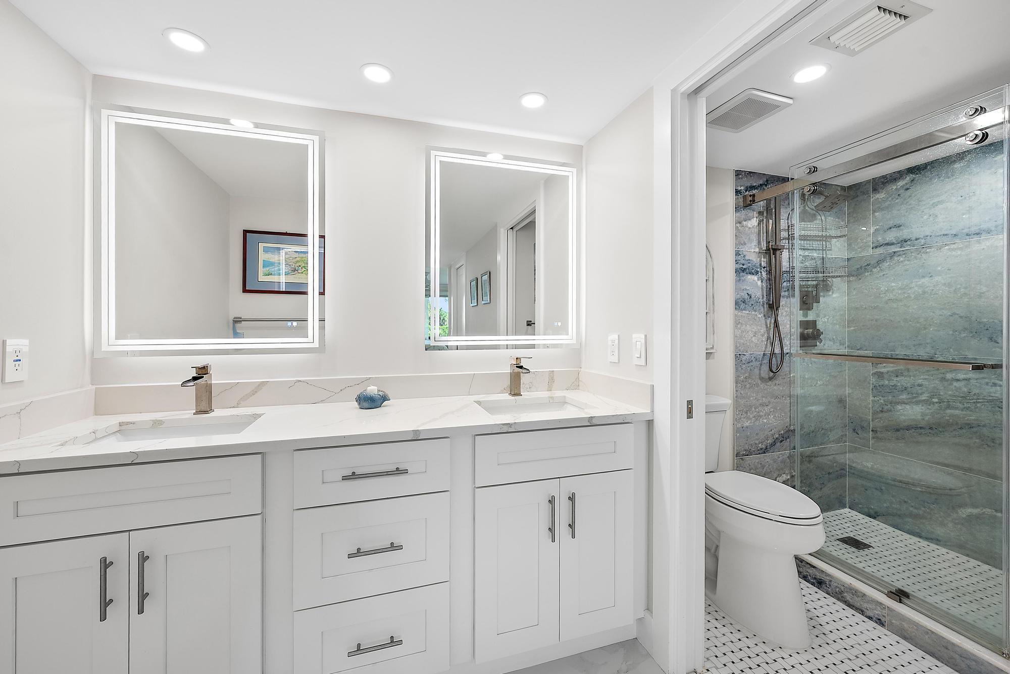 3693 Quail Ridge Drive, Unit BOBWHITE B Boynton Beach, FL 33436 - Photo 20 of 39 a bathroom with a double vanity sink toilet mirror and shower