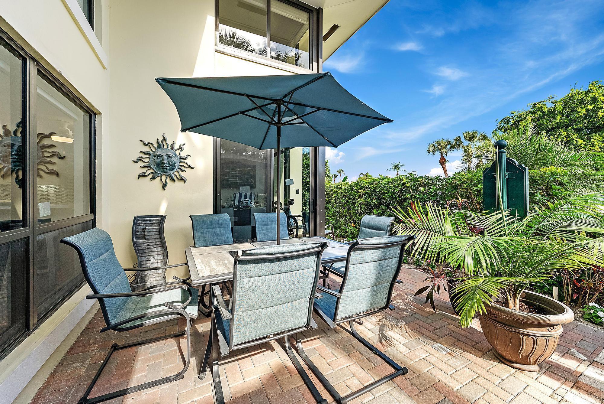 3693 Quail Ridge Drive, Unit BOBWHITE B Boynton Beach, FL 33436 - Photo 2 of 39 a view of an outdoor sitting area with furniture and umbrella