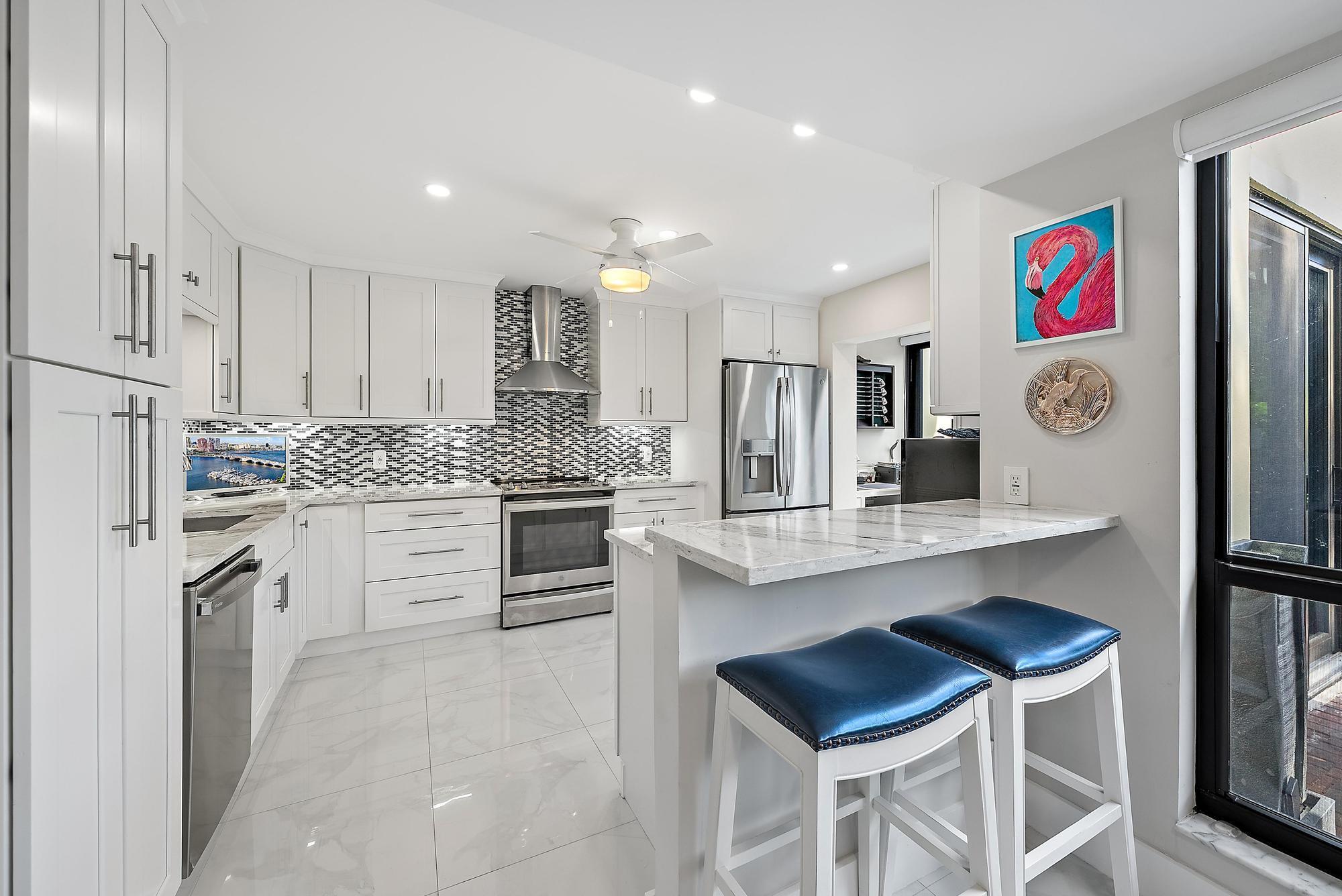 3693 Quail Ridge Drive, Unit BOBWHITE B Boynton Beach, FL 33436 - Photo 3 of 39 a kitchen with granite countertop cabinets and stainless steel appliances
