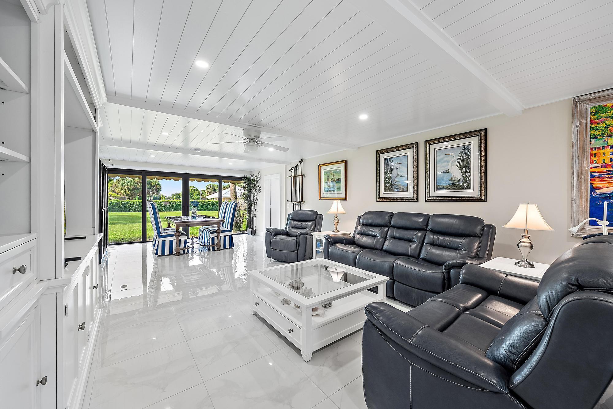 3693 Quail Ridge Drive, Unit BOBWHITE B Boynton Beach, FL 33436 - Photo 4 of 39 a living room with furniture large windows and wooden floor