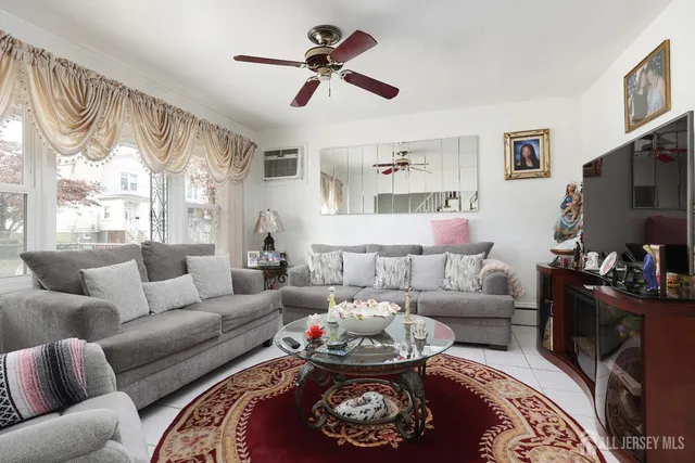 a living room with furniture a rug and a flat screen tv