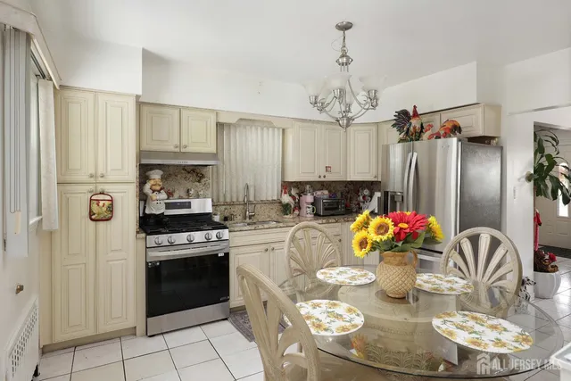 a kitchen with stainless steel appliances kitchen island granite countertop a refrigerator stove and white cabinets