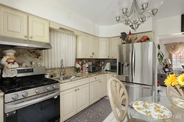a kitchen with stainless steel appliances granite countertop a refrigerator sink and stove