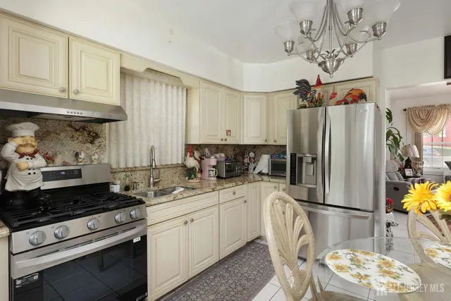 a kitchen with stainless steel appliances granite countertop a refrigerator sink and stove