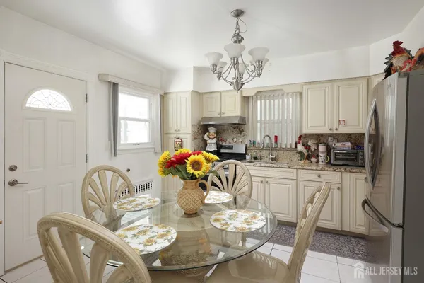 a very nice looking dining room with furniture a chandelier and window