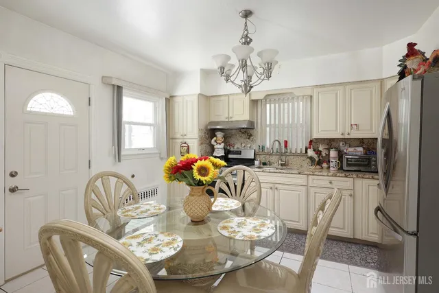 a very nice looking dining room with furniture a chandelier and window
