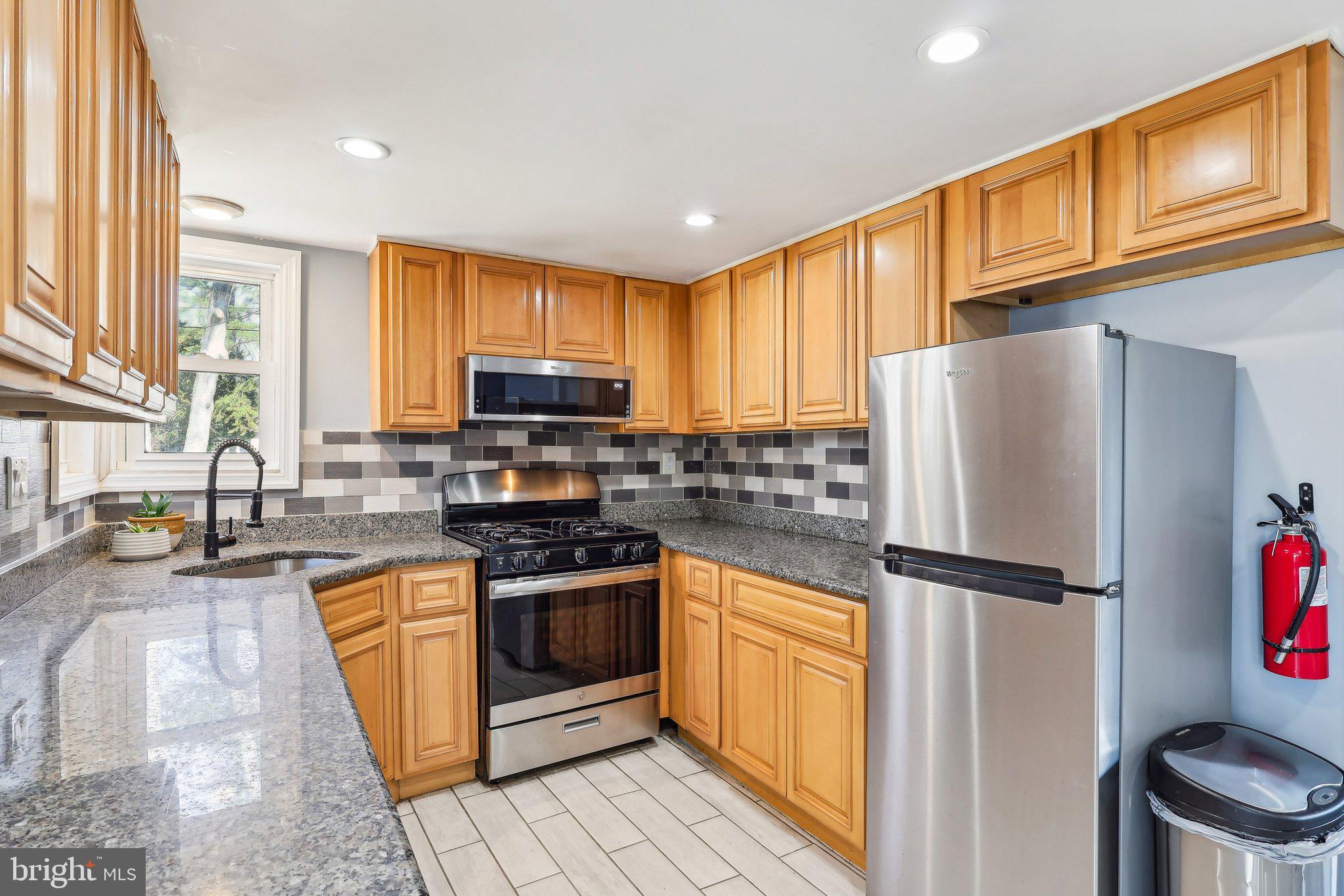 96 East 9th Avenue Pine Hill, NJ 08021 - Photo 11 of 31 a kitchen with granite countertop stainless steel appliances a refrigerator a stove top oven and a refrigerator
