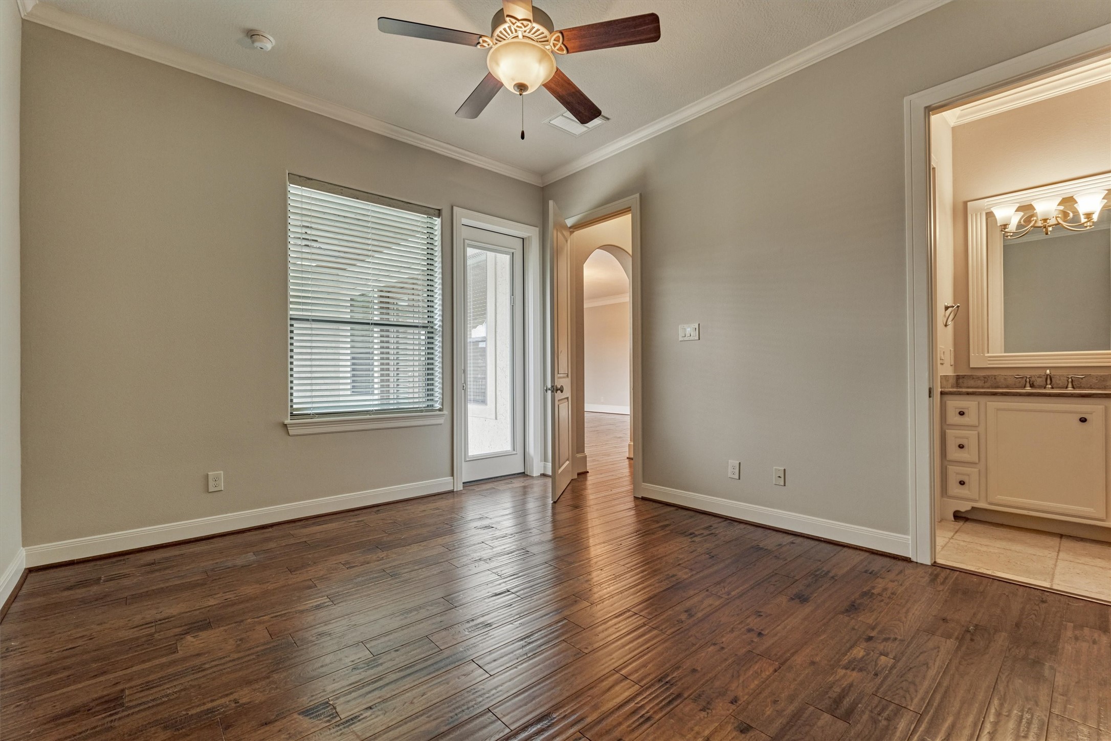 25 Post Shadow Estate Drive Spring, TX 77389 - Photo 36 of 49 Sunlit bedroom with rich hardwood floors, crown molding, ceiling fan, and direct access to ensuite bath.