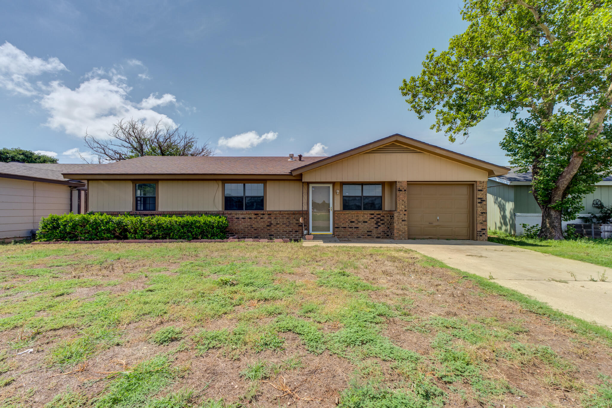 1313 Adrian Street Lubbock, TX 79403 - Photo 1 of 26 a front view of a house with a garden