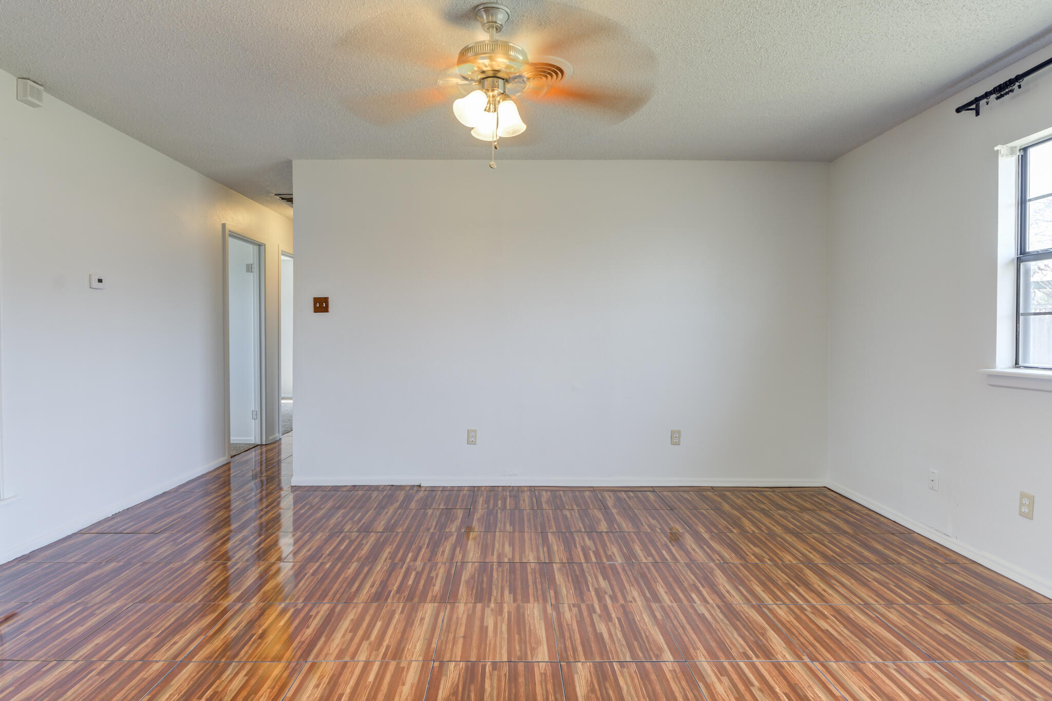 1313 Adrian Street Lubbock, TX 79403 - Photo 15 of 26 a view of empty room with wooden floor and fan