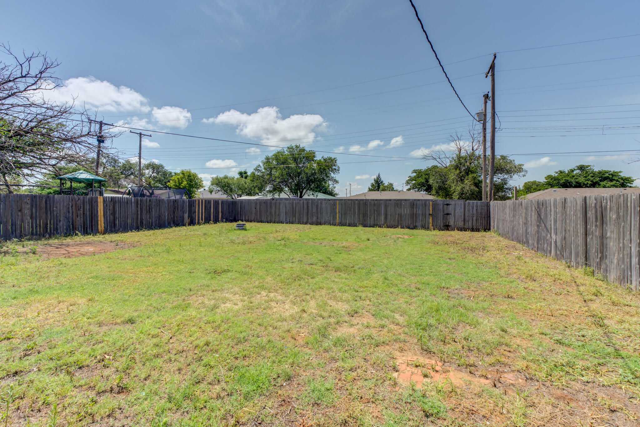 1313 Adrian Street Lubbock, TX 79403 - Photo 25 of 26 a swimming pool with some trees in the background