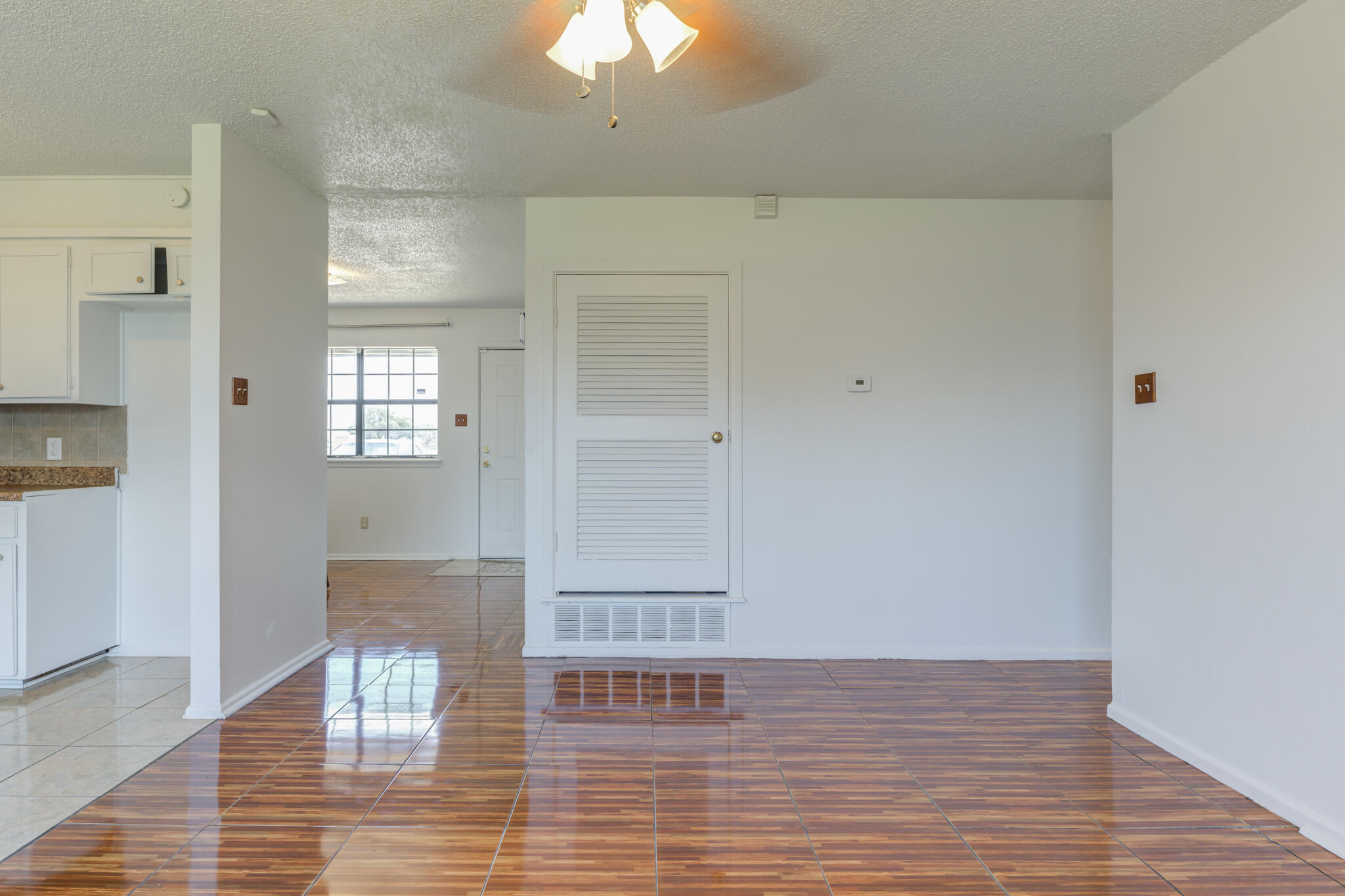 1313 Adrian Street Lubbock, TX 79403 - Photo 10 of 26 a view of empty room with wooden floor and fan