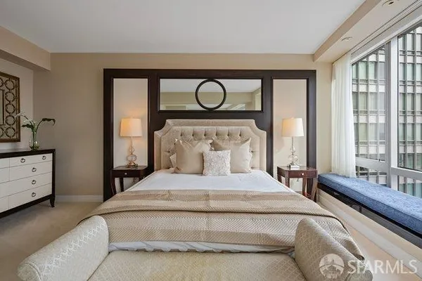 a bedroom with a bed and large windows