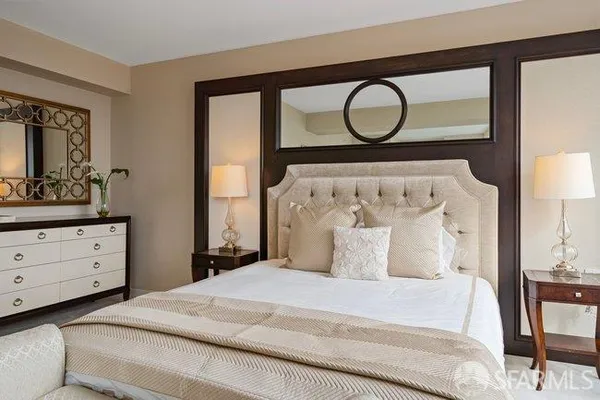 a bedroom with a large bed and a large mirror