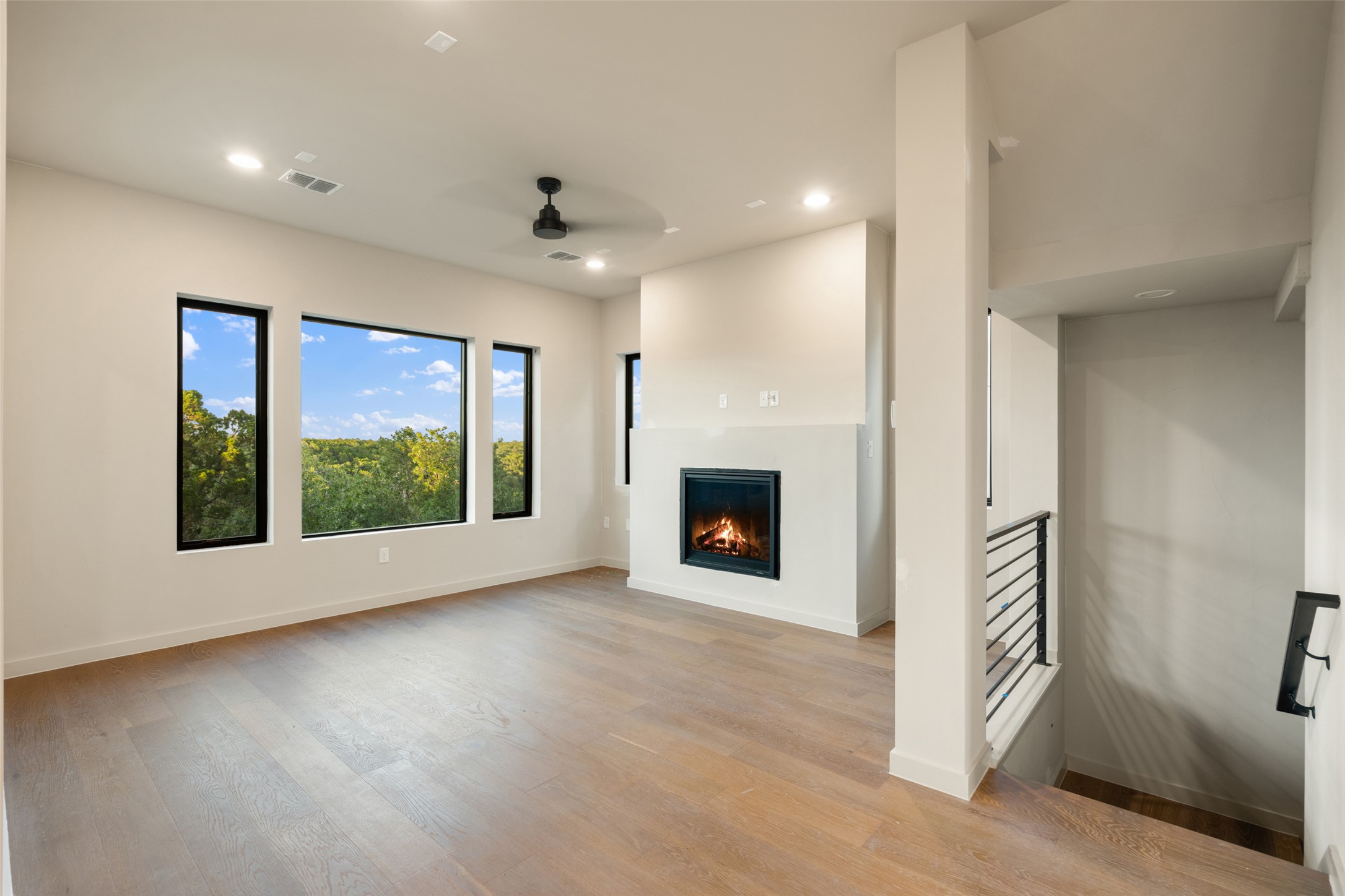 9803 Ribelin Ranch Court, Unit 16 Austin, TX 78750 - Photo 10 of 31 Gleaming hardwood floors and a modern fireplace elevate this inviting living space.