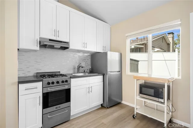 a kitchen with granite countertop white cabinets and white stove