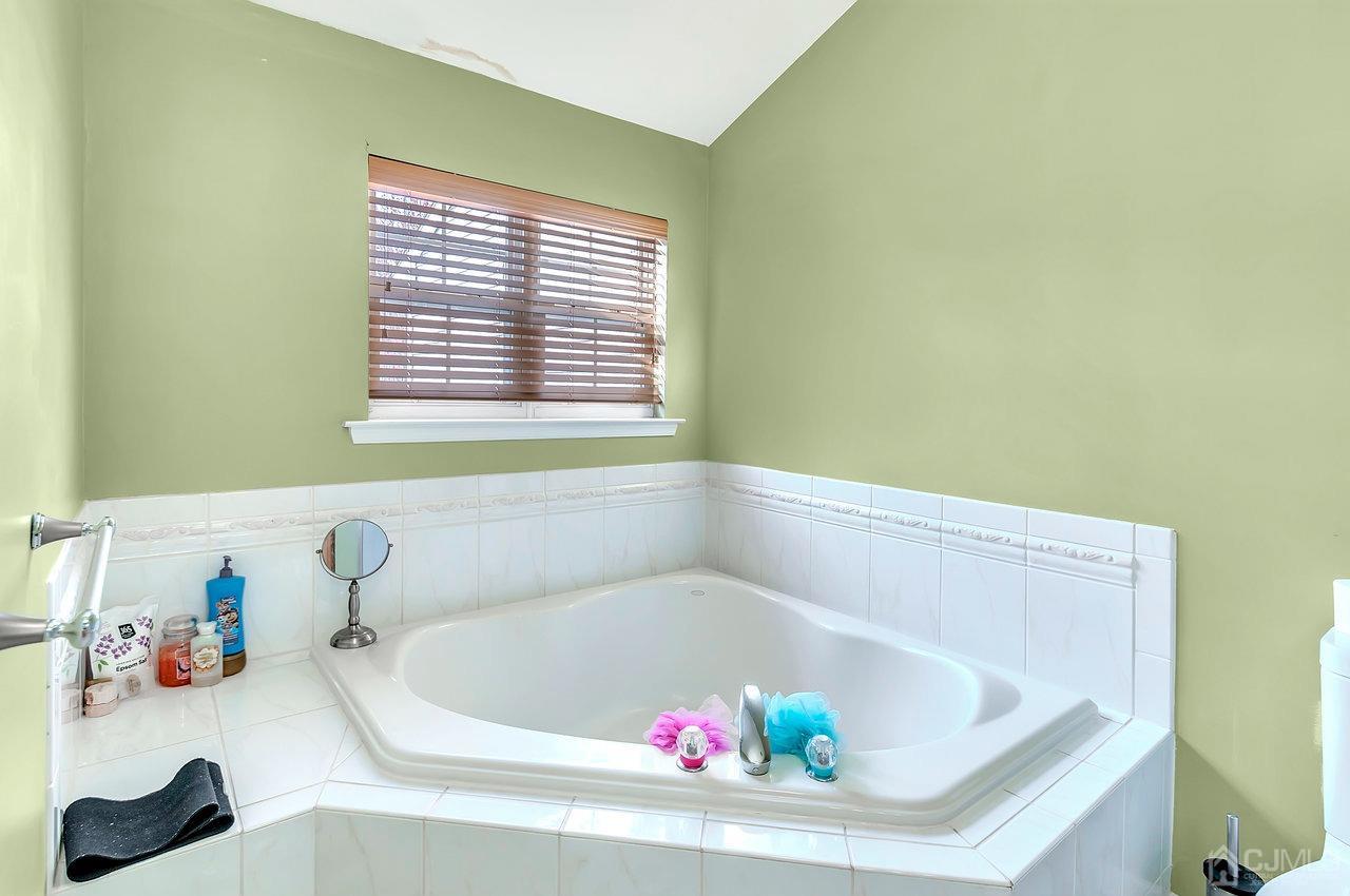 5 Rondell Lane, Unit 198 Old Bridge, NJ 08879 - Photo 19 of 23 a white bath tub sitting in a bathroom next to a window