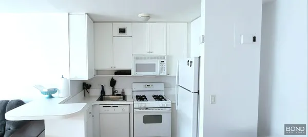 a view of a kitchen with a white cabinets
