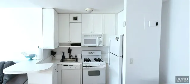 a view of a kitchen with a white cabinets