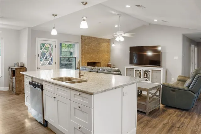 a kitchen with stainless steel appliances a stove a sink a oven a dining table and chairs