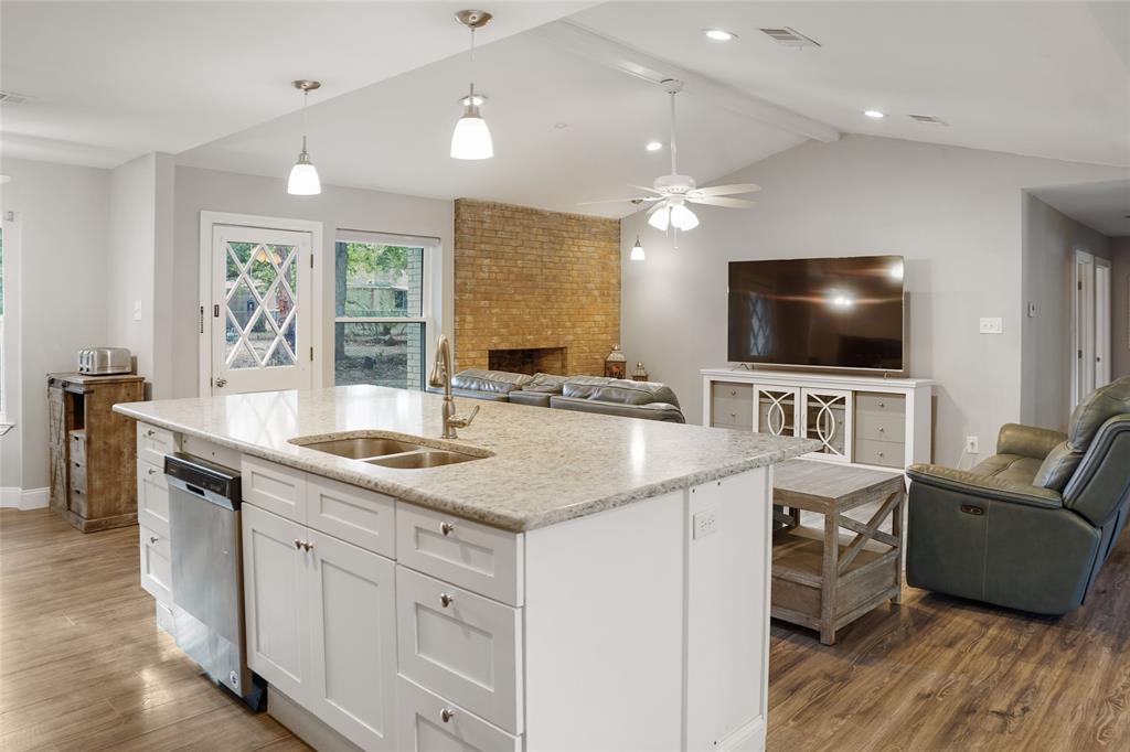 a kitchen with stainless steel appliances a stove a sink a oven a dining table and chairs