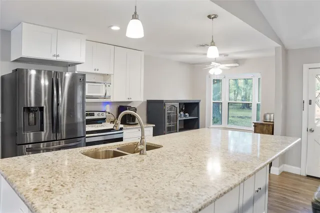 a kitchen with stainless steel appliances granite countertop a sink refrigerator and cabinets