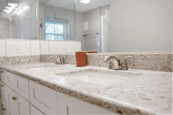 a bathroom with a granite countertop sink and a mirror