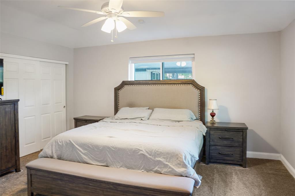 3011 Tanglewood Drive Commerce, TX 75428 - Photo 21 of 40 a bedroom with a bed and a chandelier