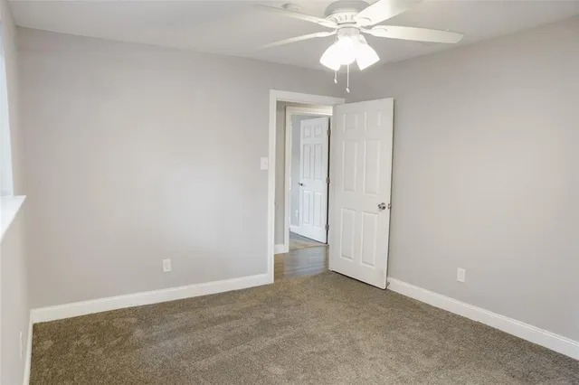 an empty room with a fan and a ceiling fan