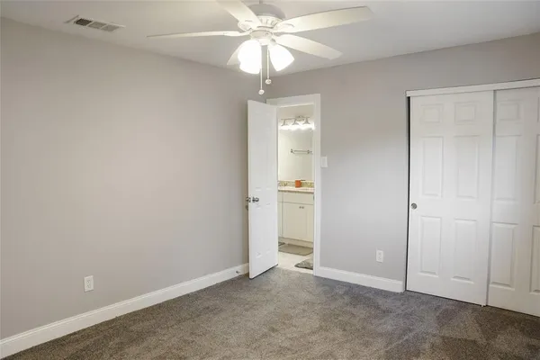 an empty room with closet and fan