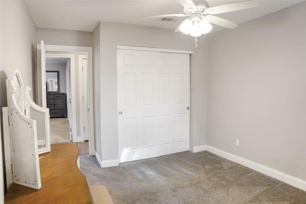 3011 Tanglewood Drive Commerce, TX 75428 - Photo 32 of 40 an empty room with closet and a chandelier fan
