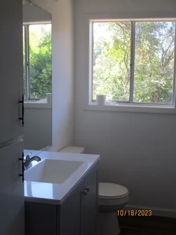a bathroom with a sink a toilet and a window