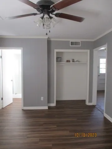 a view of an empty room with wooden floor