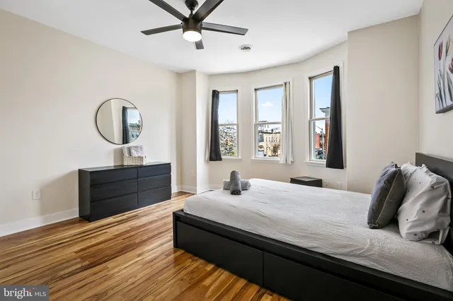 a bedroom with bed and wooden floor
