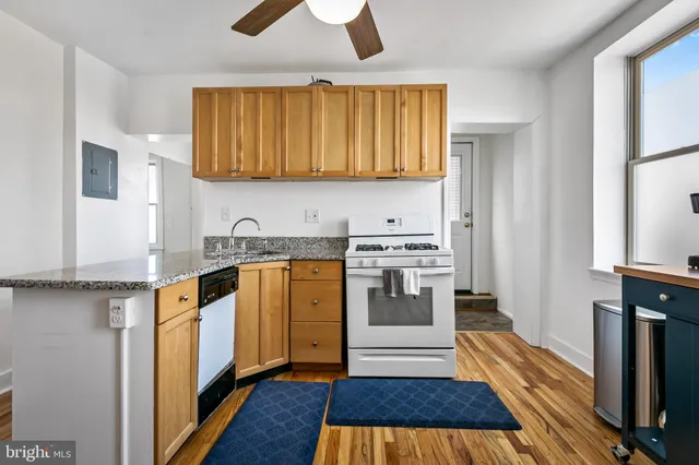 a view of a kitchen with sink stove and wooden floor