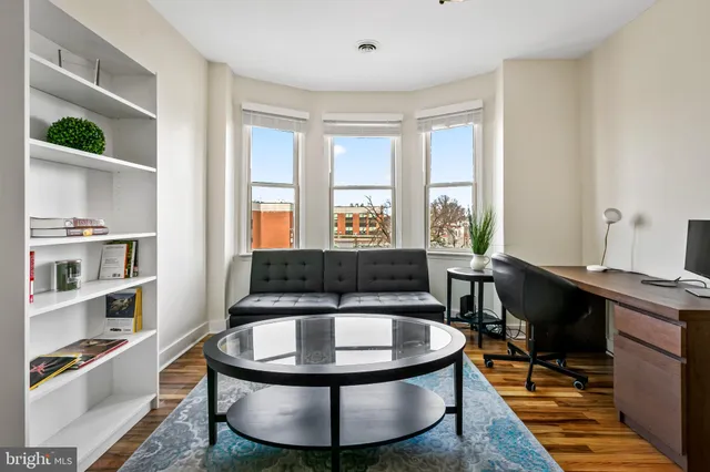 a living room with furniture a rug and a large window
